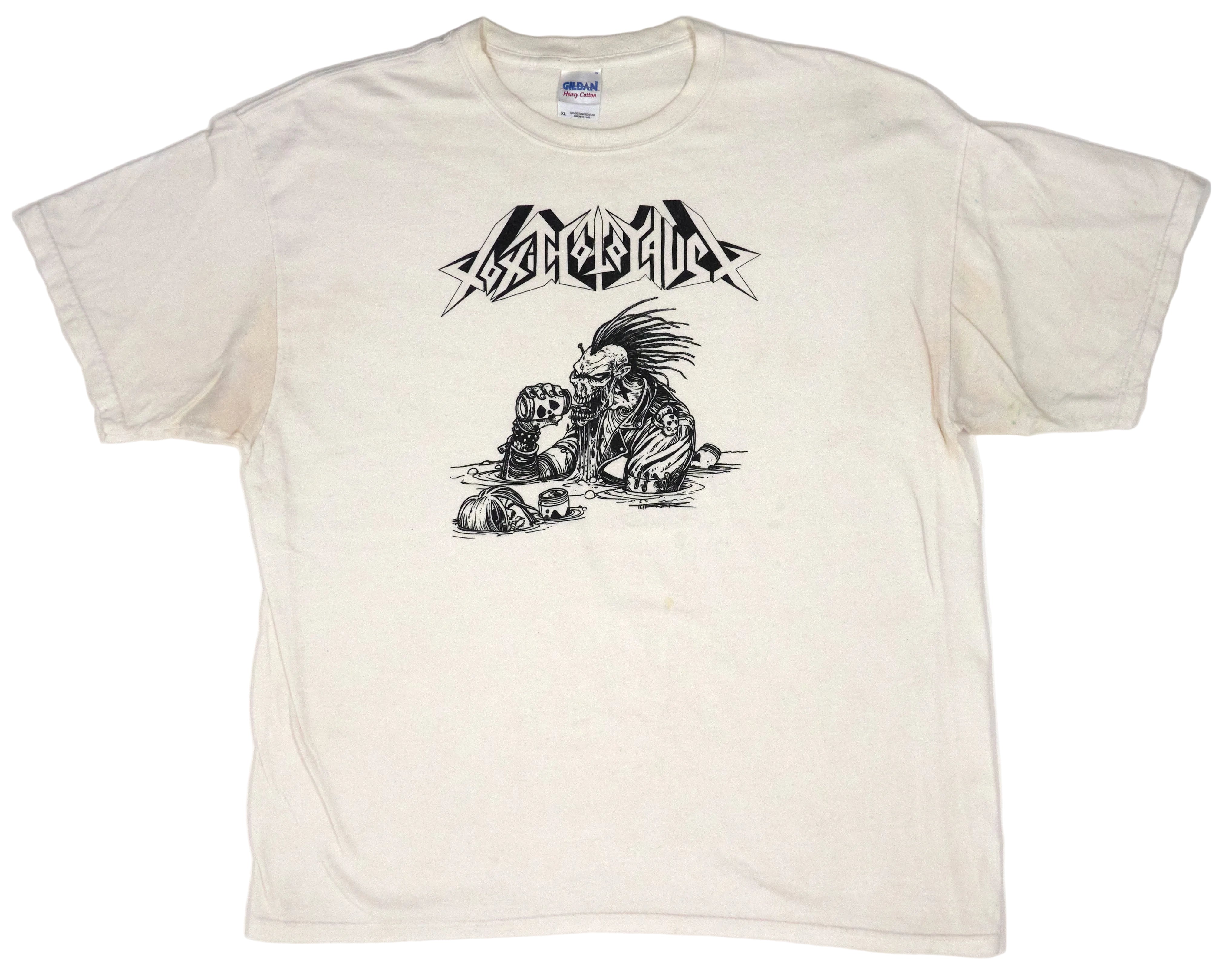 A white t-shirt with a graphic print of a character and text related to Toxic Holocaust, indicating it is merchandise from a concert or tour.
