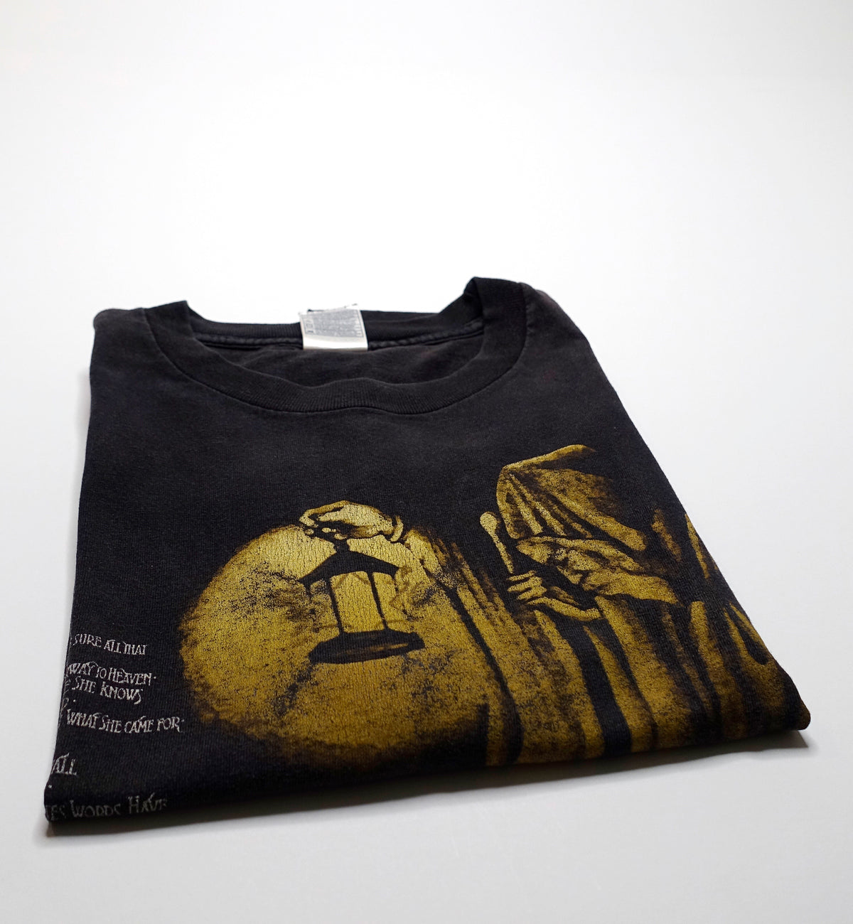 This image displays a vintage Led Zeppelin t-shirt in a large size, characterized by a dark color with a striking yellow and black graphic print of a figure holding a lantern, reminiscent of the album cover for "Stairway to Heaven." The shirt shows minor wear at the armpit seams, highlighting its vintage nature and the passage of time.